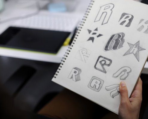 Hand Holding Notebook With Drew Brand Logo Creative Design Ideas